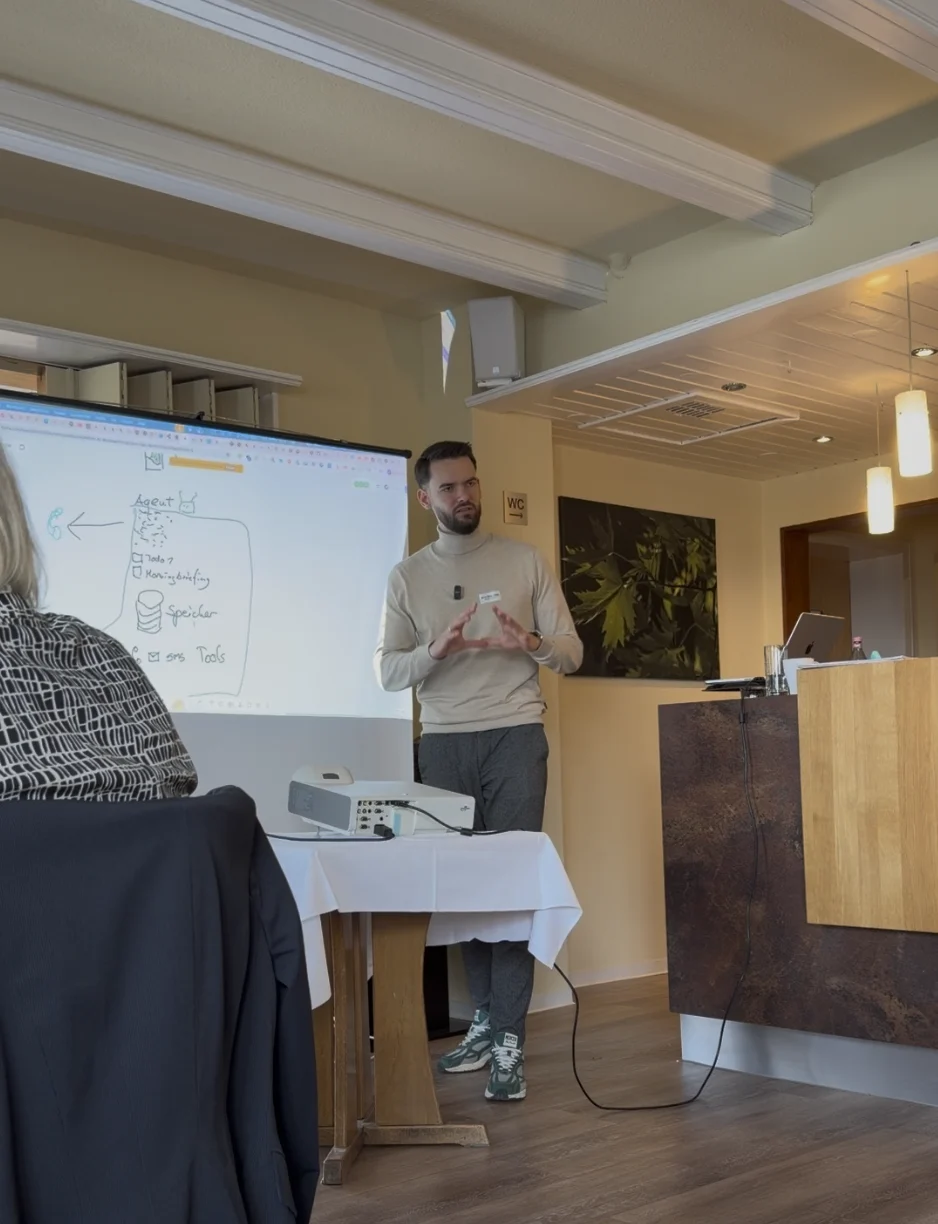 Micha von sorum bespricht vor einem Team die Architektur eines KI-Agenten an einer live entwickelten Systemskizze
